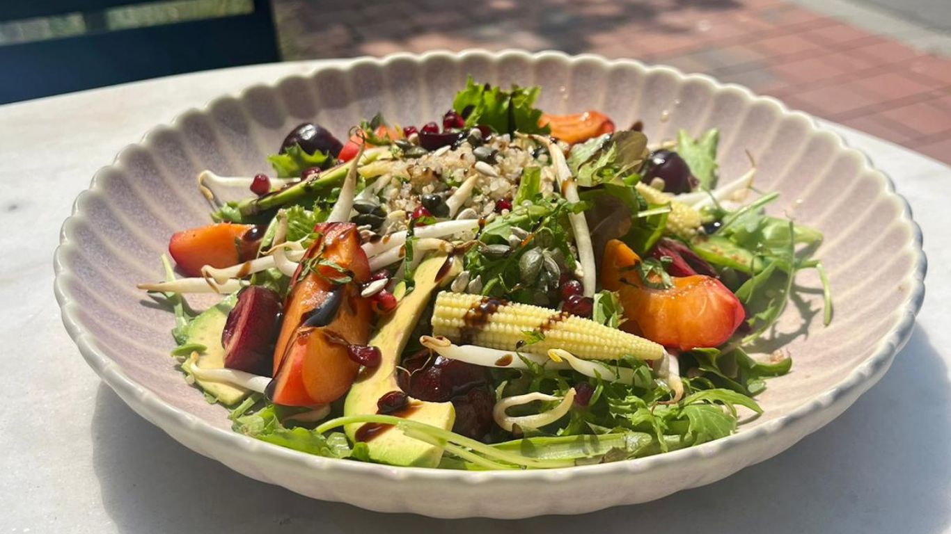 Verse seizoensalade met avocado, kersen en balsamico, geserveerd op het terras
